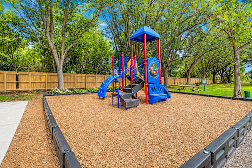 A playground with a blue and red swing set.