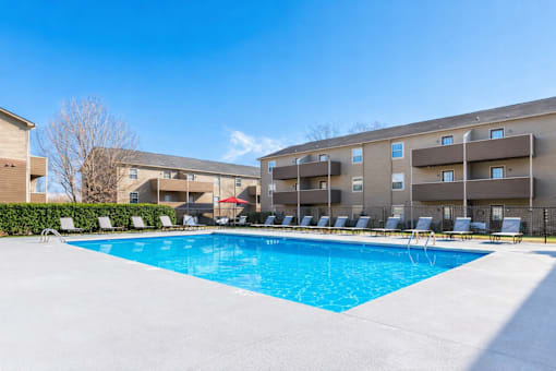 A swimming pool in front of apartment buildings.