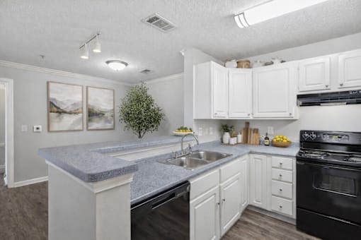 A kitchen with a granite countertop and white cabinets.