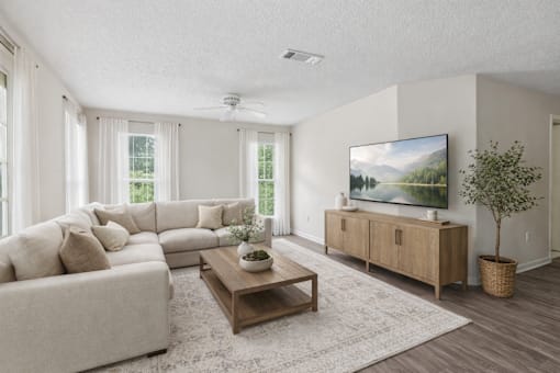 A living room with a large couch, a coffee table, and a television.
