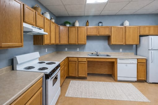 A kitchen with wooden cabinets and a white stove top oven.