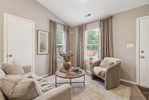 Cozy living room with neutral furnishings and windows at Delta Crossing Apartments, North Carolina, 28212