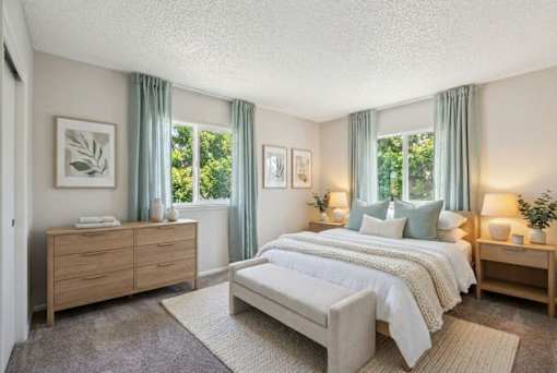 A bedroom with a large bed, a dresser, and two nightstands.