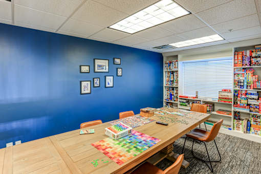 Game room with puzzle table and board game storage at The Beckstead Apartments, South Jordan, UT