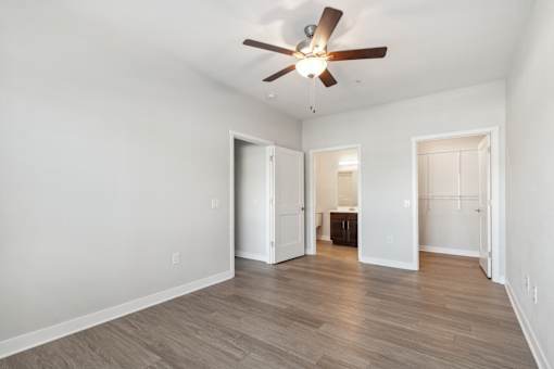 A room with a ceiling fan and wooden flooring.