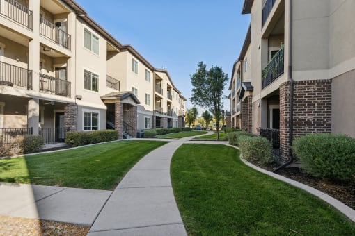 a walkway between two apartment buildings on a sunny day