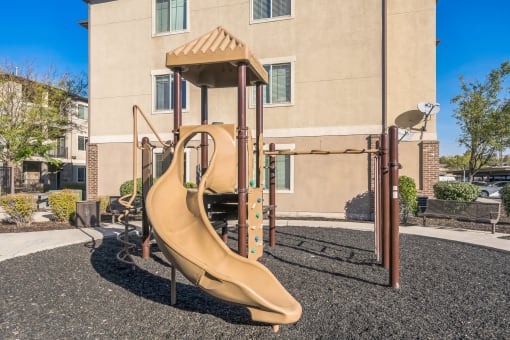 a playground with a slide in front of a building