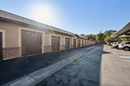 a row of garages and cars parked outside of a building