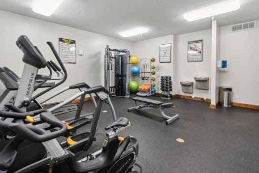 the gym with treadmills and other equipment at the enclave at woodbridge apartments