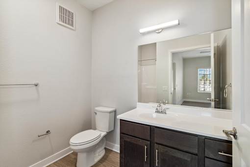 A white toilet sits next to a sink in a bathroom.