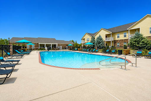 A large swimming pool surrounded by lounge chairs and umbrellas.