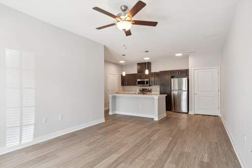 A room with a ceiling fan and wooden flooring.