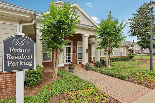A sign that says "Future Resident Parking" stands in front of a house.