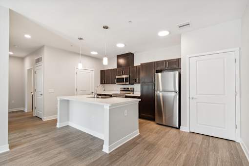 A kitchen with a white island and stainless steel appliances.