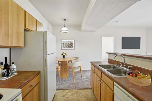A kitchen with wooden cabinets and a refrigerator.