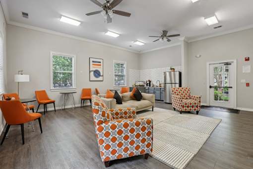 A living room with orange chairs and a patterned sofa.