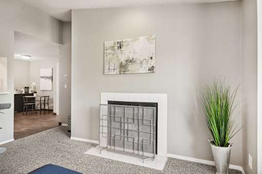 A living room with a fireplace and a painting on the wall.