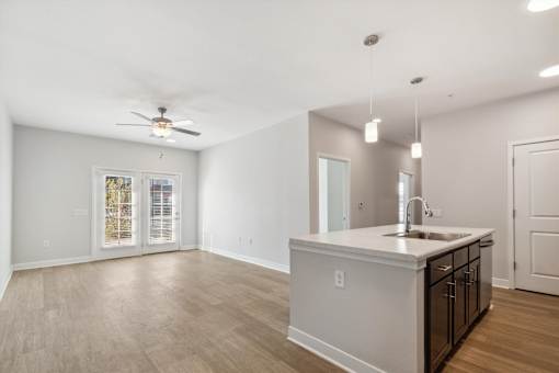 A spacious kitchen with a sink, stove, and cabinets.