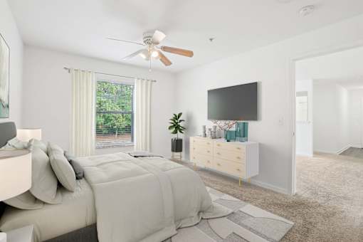 A bedroom with a large bed and a flat screen TV mounted on the wall.