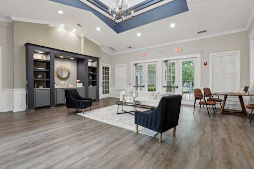 A living room with a black chair and a wooden floor.