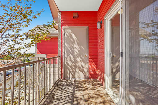 A red house with a white door and a balcony.