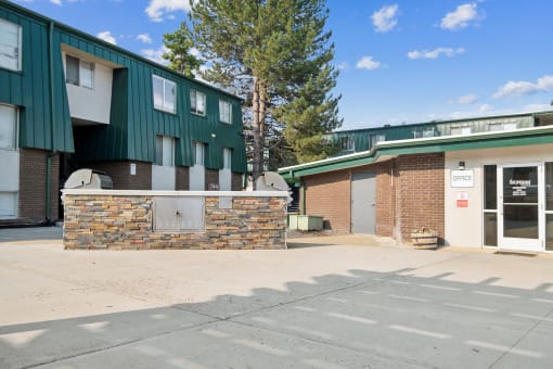 a building with a brick and green facade and a parking lot