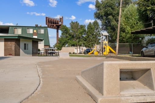 a park with a playground and a building in the background
