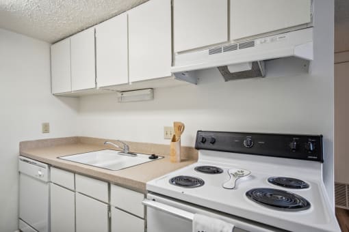 a kitchen with a stove top oven and a sink