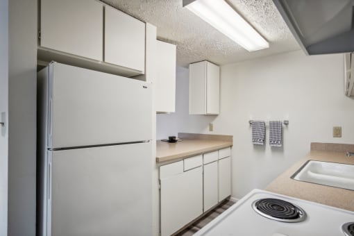 a kitchen with white appliances and a white refrigerator