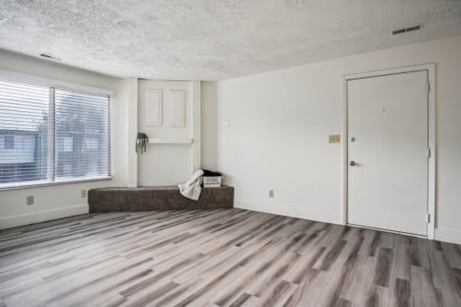 an empty living room with a window and a door