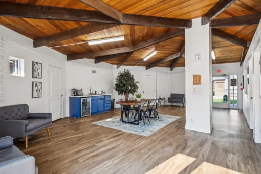 a living room with a wooden ceiling and a table and chairs