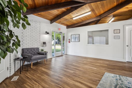 a living room with white walls and a wooden ceiling and a sliding glass door