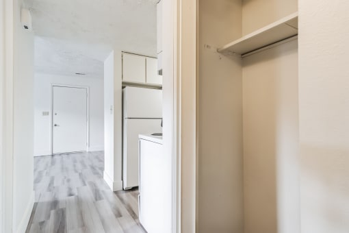 an empty kitchen with white cabinets and a wood floor