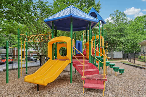A playground with a yellow slide and a blue roof.