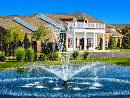 A house with a water fountain in front of it.