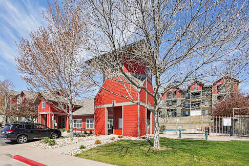 A red building with a black car parked in front.