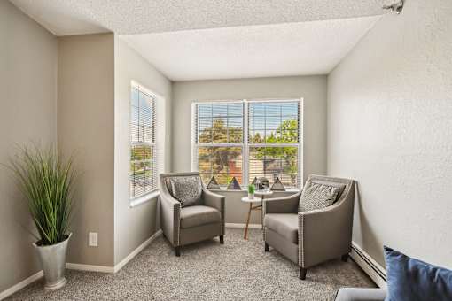 A sunny room with two chairs and a table.