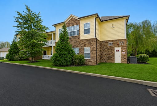 A two-story apartment building with a yellow and brown exterior.