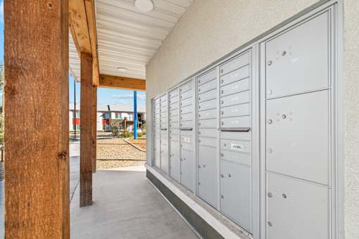 A long row of mailboxes are lined up on the side of a building.