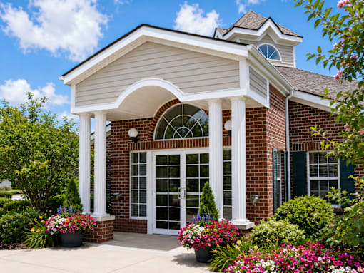 A house with a white roof and a brick wall with a glass door and windows.