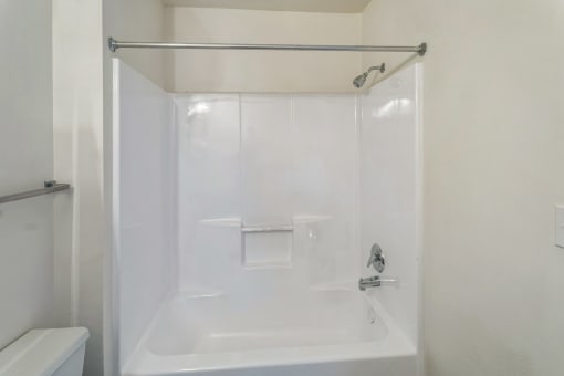 a white bathroom with a shower and a sink