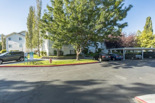 a parking lot with cars parked in front of an apartment building