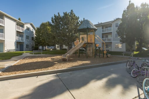 a playground with a slide in front of an apartment building