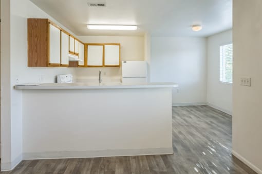 an empty kitchen with a counter top and a refrigerator