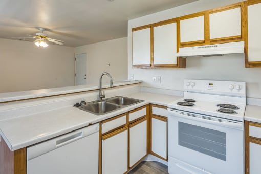an empty kitchen with white appliances and wooden cabinets