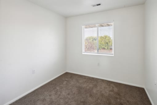an empty room with carpet and a window