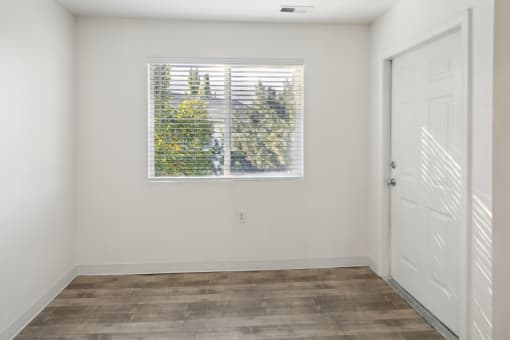 an empty room with a window and a door
