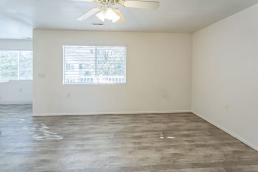 an empty living room with white walls and a window
