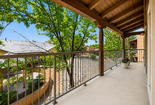 A balcony with a metal railing and a concrete floor.