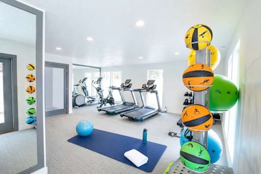 Fitness center with cardio equipment and yoga area at Creekview Apartments, Midvale, 84047
